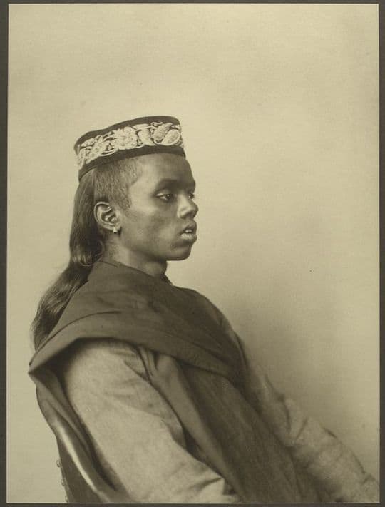 Sepia-toned portrait of a young man wearing a traditional hat and clothing.